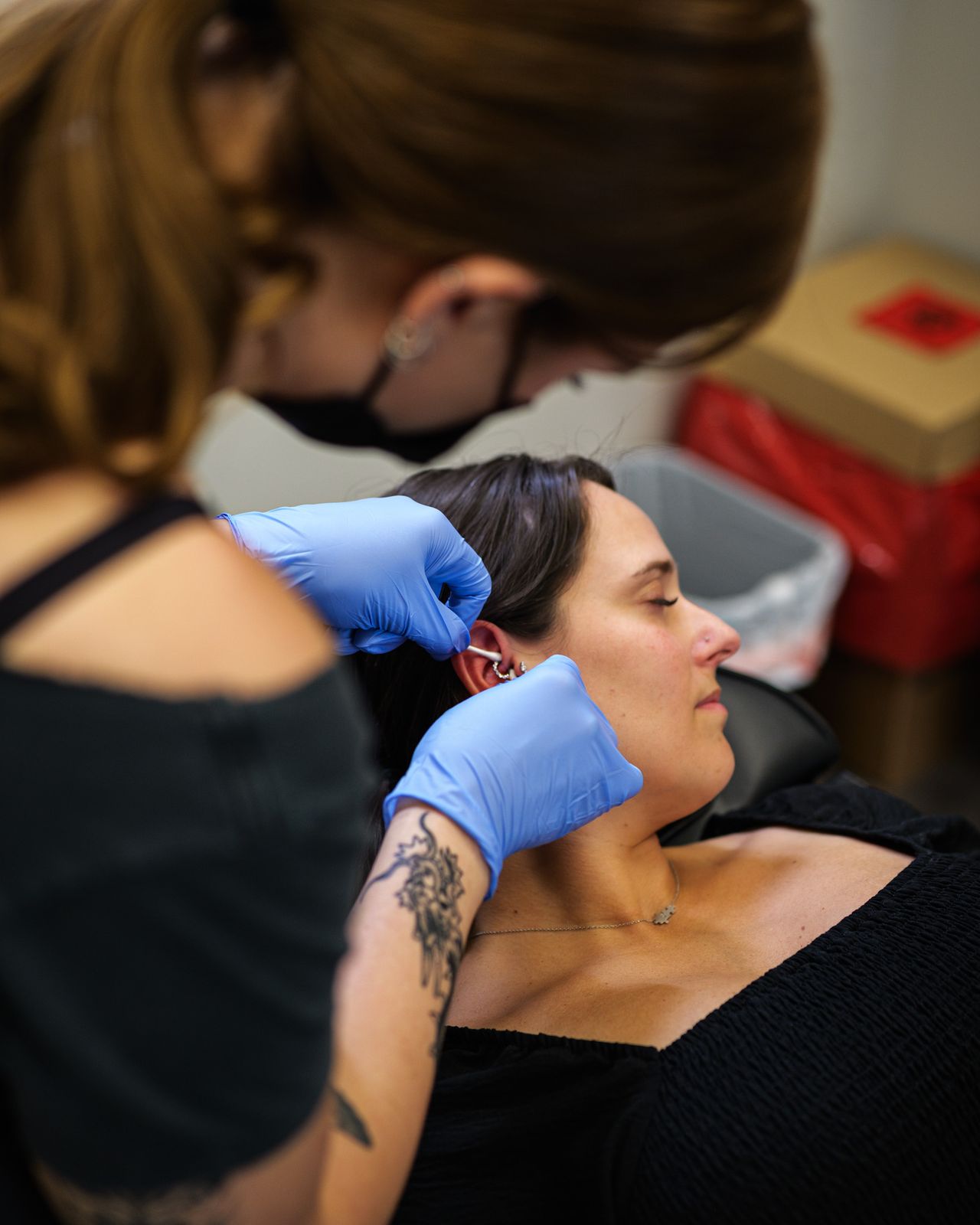 Piercer working on a client's ear